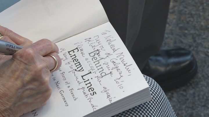 Marthe Cohn signs a copy of her book, “Behind Enemy Lines: The True Story of a French Jewish Spy in Nazi Germany,” for Calgary Mayor Naheed Nenshi on Sunday.