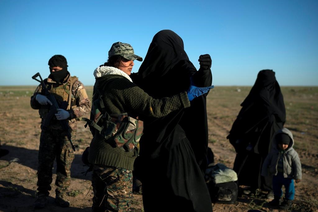 U.S.-backed Syrian Democratic Forces fighter frisks woman fleeing during the collapse of ISIS, Baghouz, Syria, on March 1, 2019. (AP Photo/Felipe Dana).
