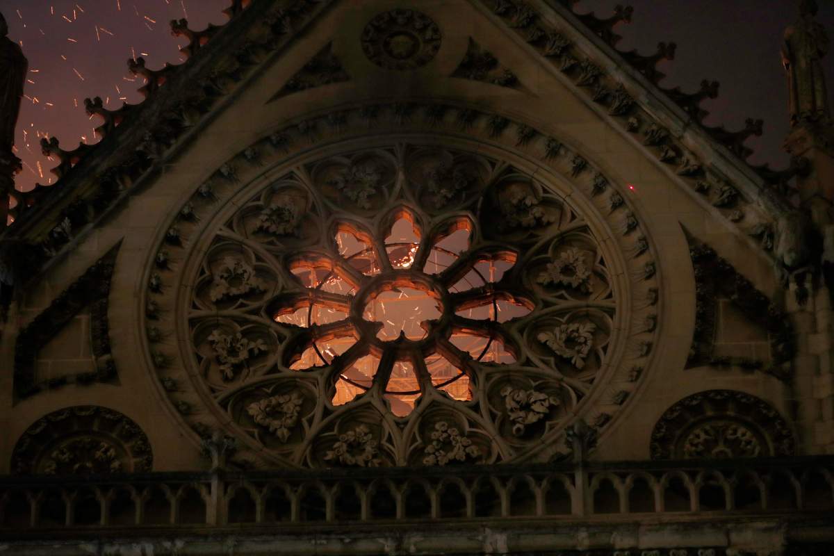 Sparks and flames are seen through a destroyed stained glass window as the Notre Dame Cathedral burns in Paris, France, April 15, 2019.