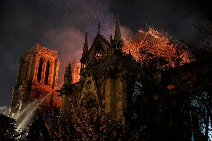 Sparks fill the air as Paris Fire Brigade members spray water to extinguish flames as the Notre Dame Cathedral burns in Paris, France April 15, 2019.