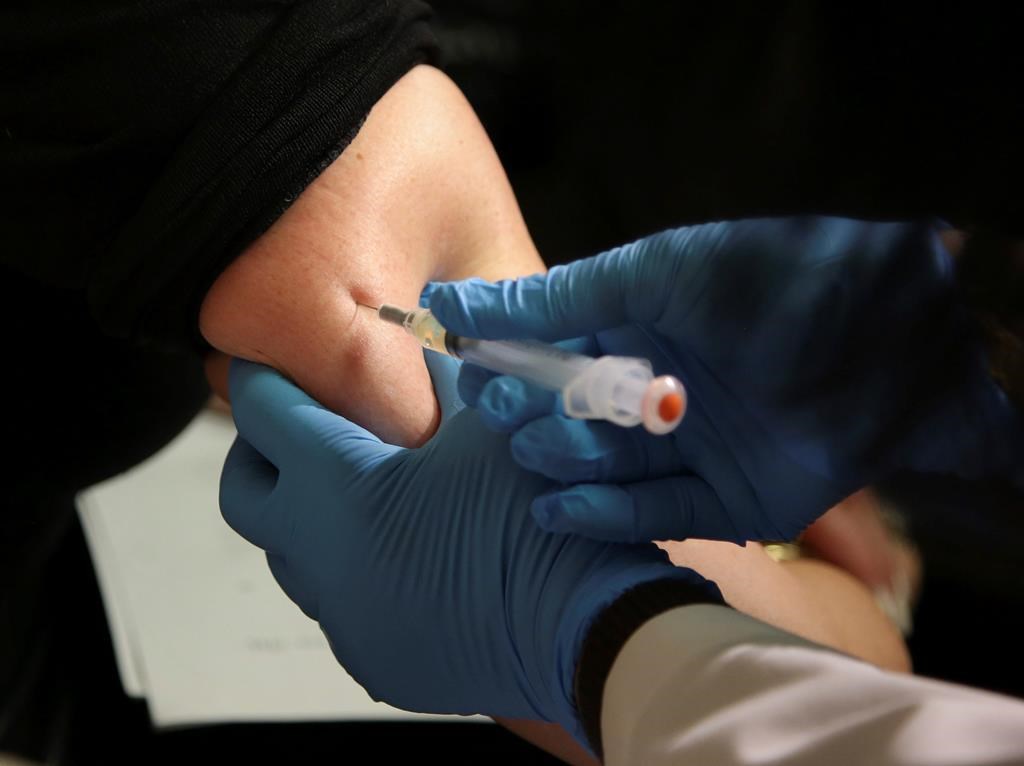 FILE - In this March 27, 2019, file photo, a woman receives a measles, mumps and rubella vaccine.