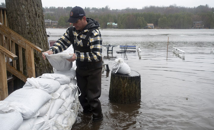 Stephen Wood places sandbags outside his property during flooding on Friday, April 26, 2019 in Ottawa. Adrian Wyld / The Canadian Press