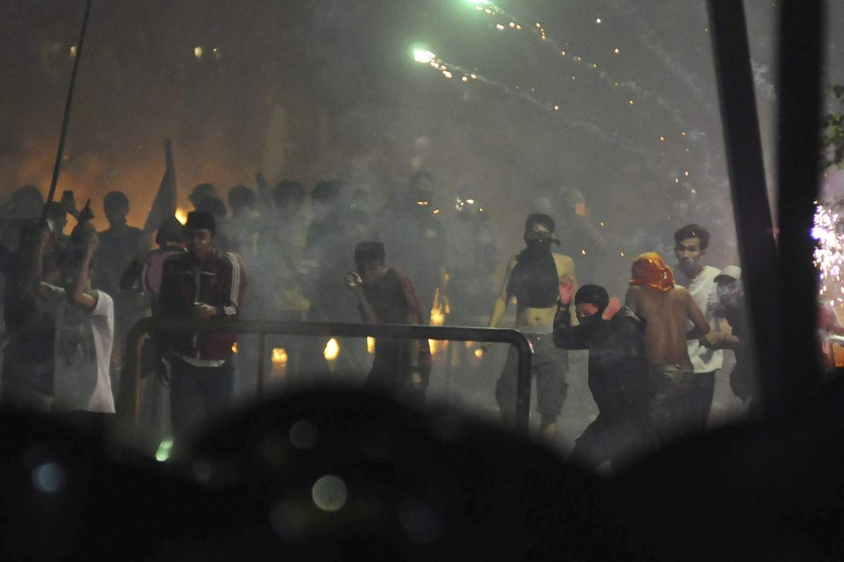 Supporters of Indonesian presidential candidate Prabowo Subianto defend during a clash with the police in Jakarta, Indonesia, early Wednesday, May 22, 2019. Supporters of the unsuccessful presidential candidate clashed with security forces and set fire to a police dormitory and vehicles in the Indonesian capital on Wednesday after the release of official election results.