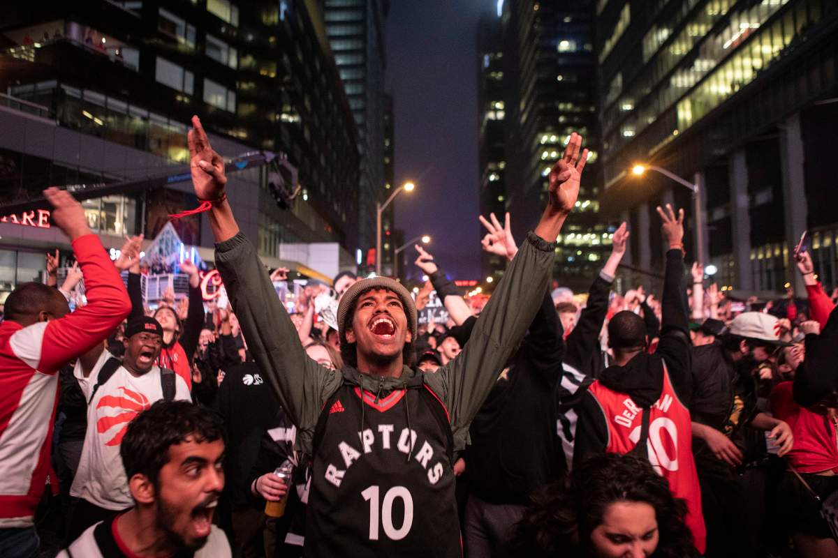 Toronto Raptors fans react as they watch game six of NBA Eastern Conference Final basketball action between the Toronto Raptors and Milwaukee Bucks on a screen outside the Scotiabank Arena, in Toronto on Saturday, May 25, 2019. 