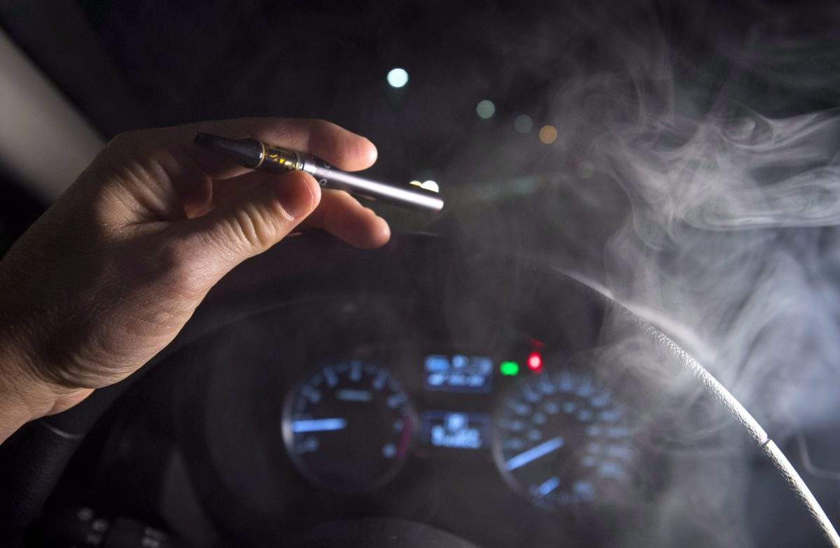 In this photo illustration, smoke from a cannabis oil vaporizer is seen as the driver is behind the wheel of a car in North Vancouver, B.C. Wednesday, Nov. 14, 2018.