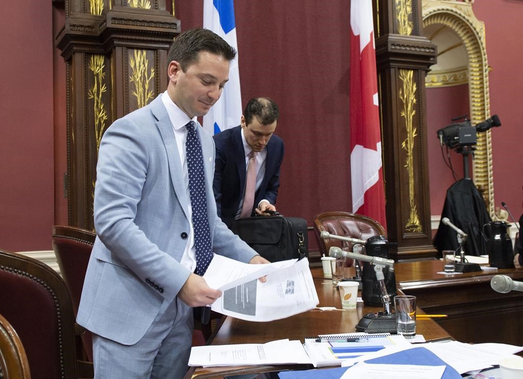 Quebec Minister of Immigration, Diversity and Inclusiveness Simon Jolin-Barrette picks up documents on the first day of a legislature committee studying a bill on secularism, Tuesday, May 7, 2019 at the legislature in Quebec City. Hearings into Quebec's secularism bill veered off track Thursday when a former senator drew a connection between the Muslim head scarf, female genital mutilation and forced marriage.