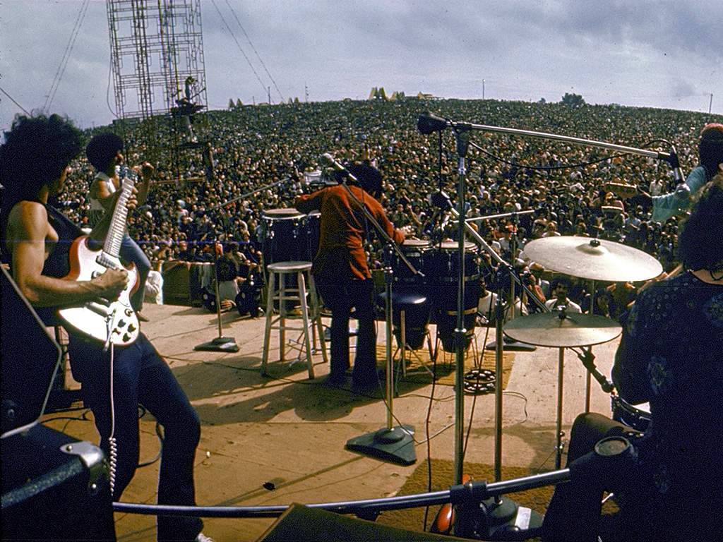 Carlos Santana (L) and his band perform on stage to a huge audience at the Woodstock Music & Art Festival, Bethel, N.Y. on Aug. 16, 1969.