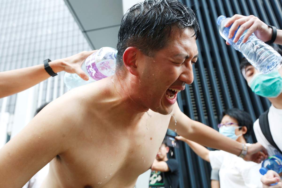 Protesters help pro-democracy lawmaker Lam Cheuk-ting who got pepper-sprayed during a demonstration against a proposed extradition bill, in Hong Kong, China June 12, 2019. 