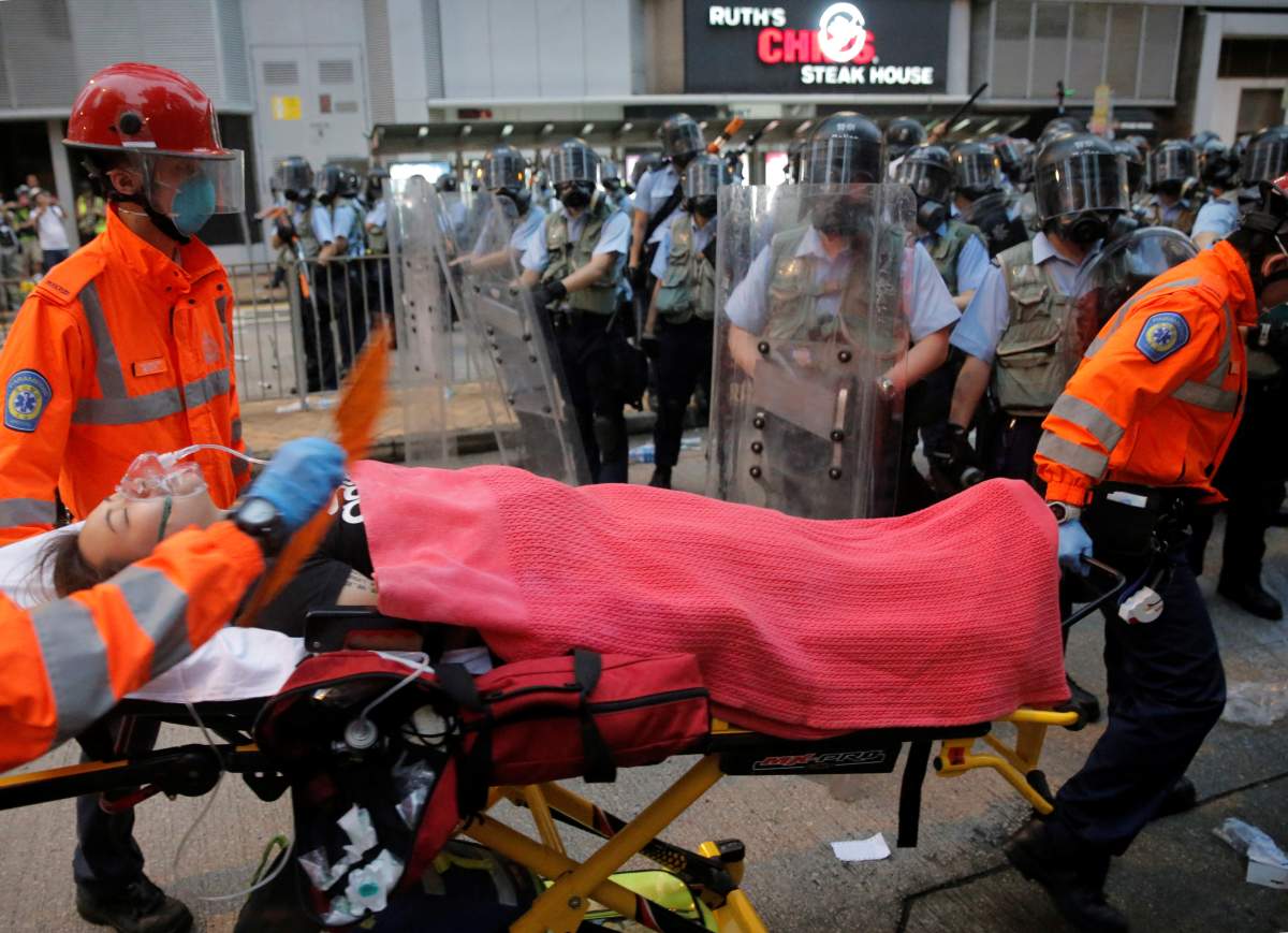 A protester is carried on a stretcher by paramedics during a demonstration against a proposed extradition bill in Hong Kong, China on June 12, 2019.