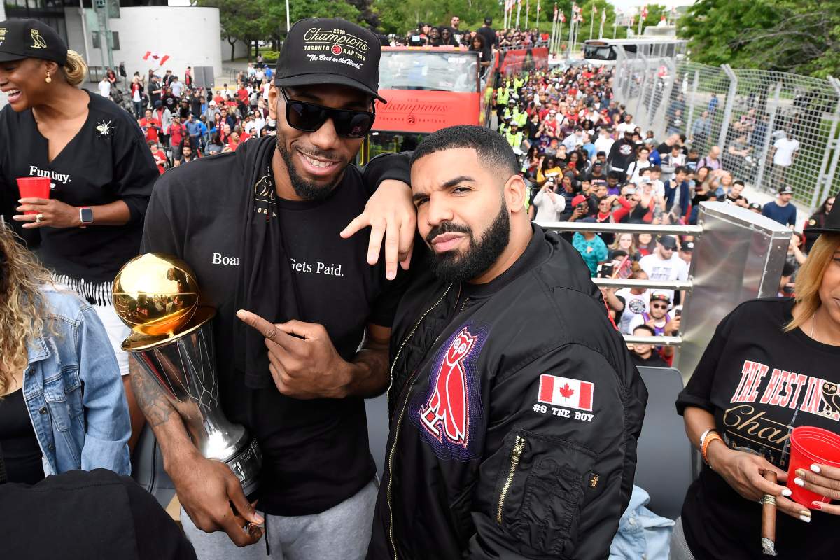 Toronto Raptors forward Kawhi Leonard points at his playoffs MVP trophy as he poses with performing artist Drake during the 2019 Toronto Raptors Championship parade in Toronto on Monday, June 17, 2019.