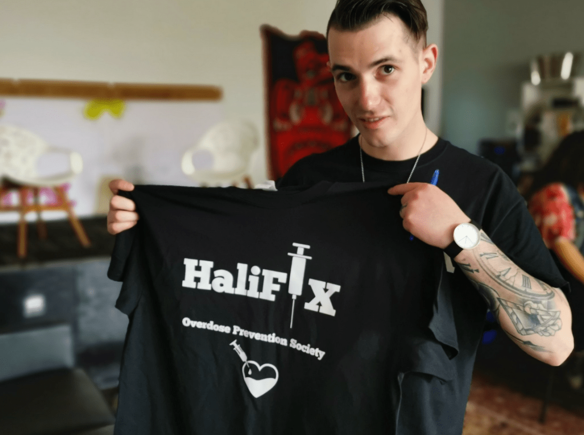 Matthew Bonn, president of the HaliFIX Overdose Prevention Society, hoolds up one of the society’s T-shirts at a naloxone training session in Halifax on Saturday, June 1, 2019.