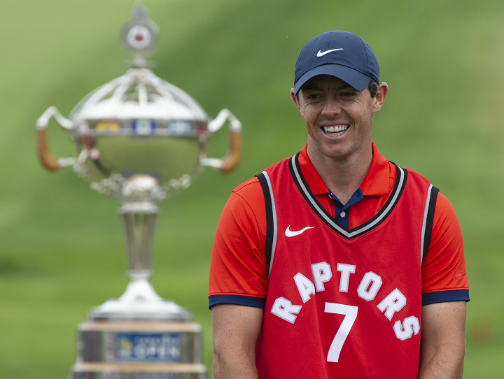 Rory McIlroy laughs as he puts on a Toronto Raptors jersey during the trophy presentation at the Canadian Open golf championship in Ancaster, Ont., on Sunday.