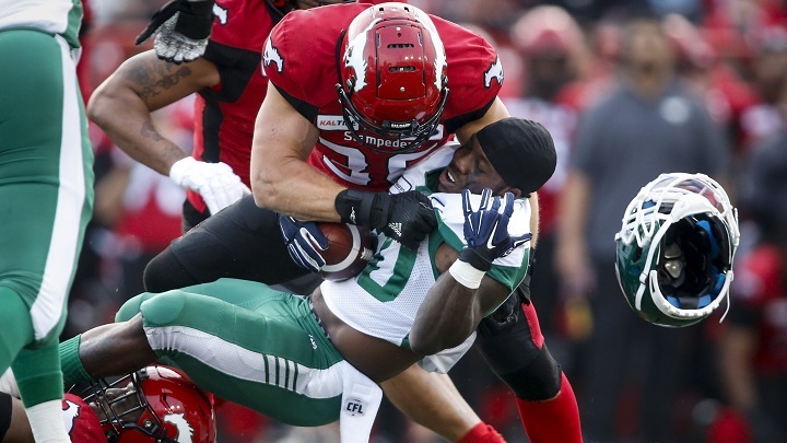 Saskatchewan Roughriders' James Butler, right, loses his helmet as he is hit by Calgary Stampeders' Cory Greenwood during CFL pre-season football action in Calgary May 31, 2019.