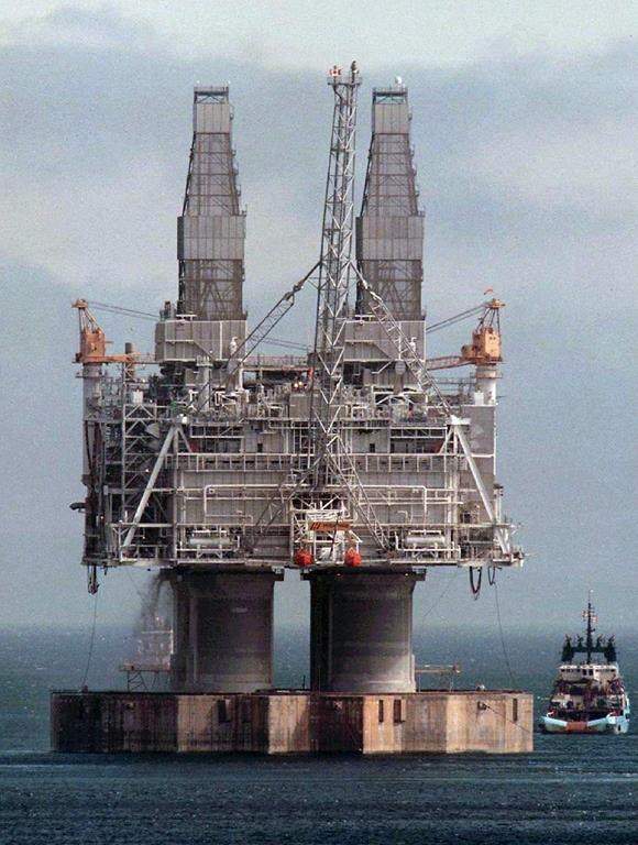 A tug positions itself near the base of the Hibernia platform in Bull Arm, Trinity Bay, Nfld., on May 22, 1997. Efforts continue off Newfoundland's east coast to monitor and clean up oil remaining from the estimated 12,000 litres that spilled from the Hibernia platform.