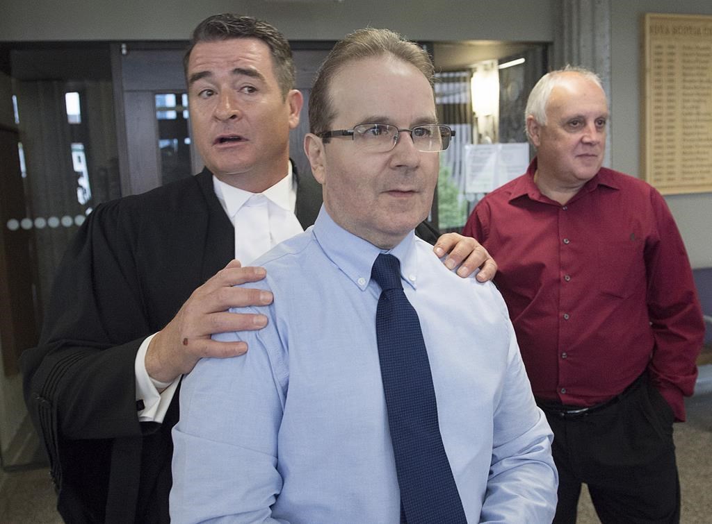 Glen Assoun, the Nova Scotia man who spent almost 17 years in prison for a crime he didn't commit, his lawyer Sean MacDonald and Ron Dalton, right, from the advocacy group Innocence Canada, stand outside Supreme Court in Halifax on Friday, July 12, 2019.