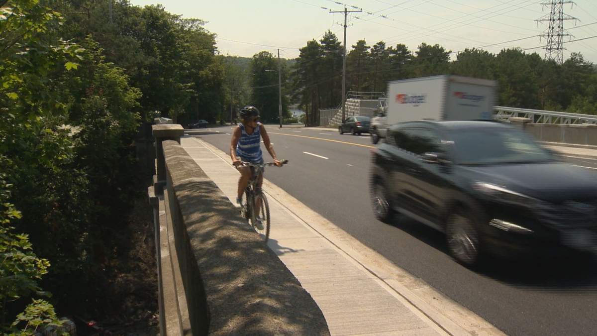 A cyclist pedals along the sidewalk next to Quinpool Rd on Monday, July 29, 2019.