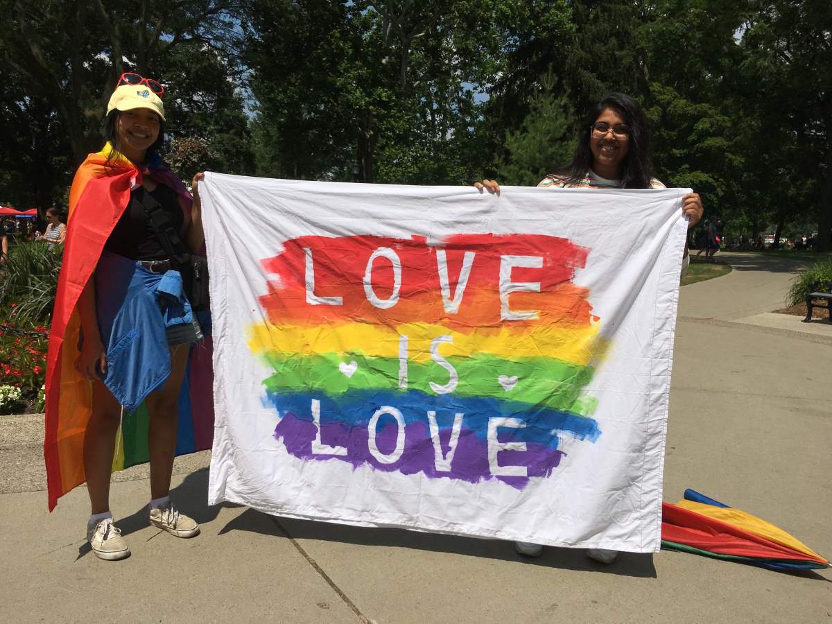 Dimple (right) and Fariah (left) showcase their homemade DIY flag at the 25th Pride Parade.