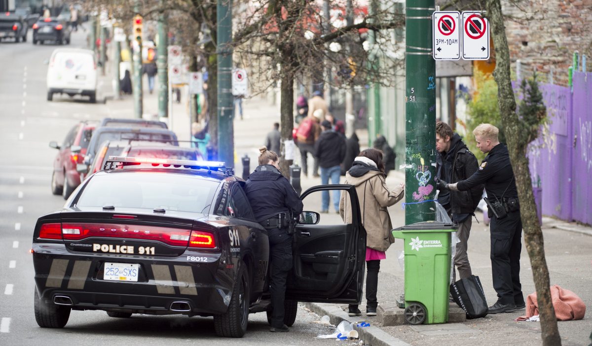 Police speak to a man and woman on East Hastings in Vancouver's downtown eastside, Thursday, Feb 7, 2019. More people fatally overdosed in British Columbia last year compared with 2017 despite efforts to combat the province's public health emergency, the coroner says. 