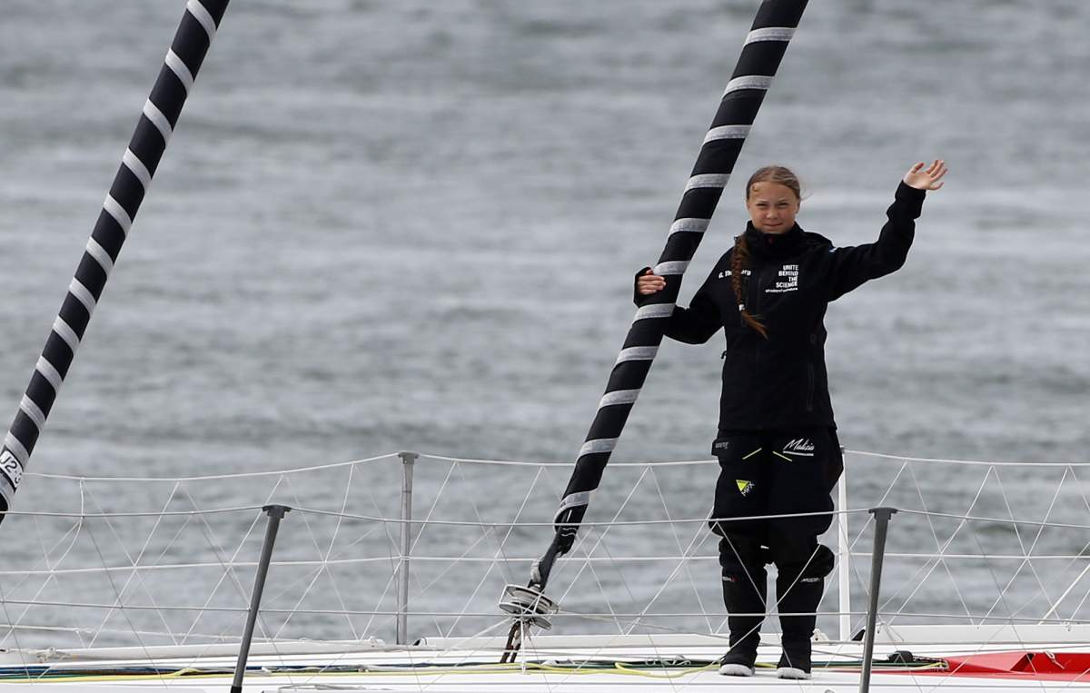 Swedish teenage climate activist Greta Thunberg waves from a yacht as she starts her trans-Atlantic boat trip to New York, in Plymouth, Britain, August 14, 2019.