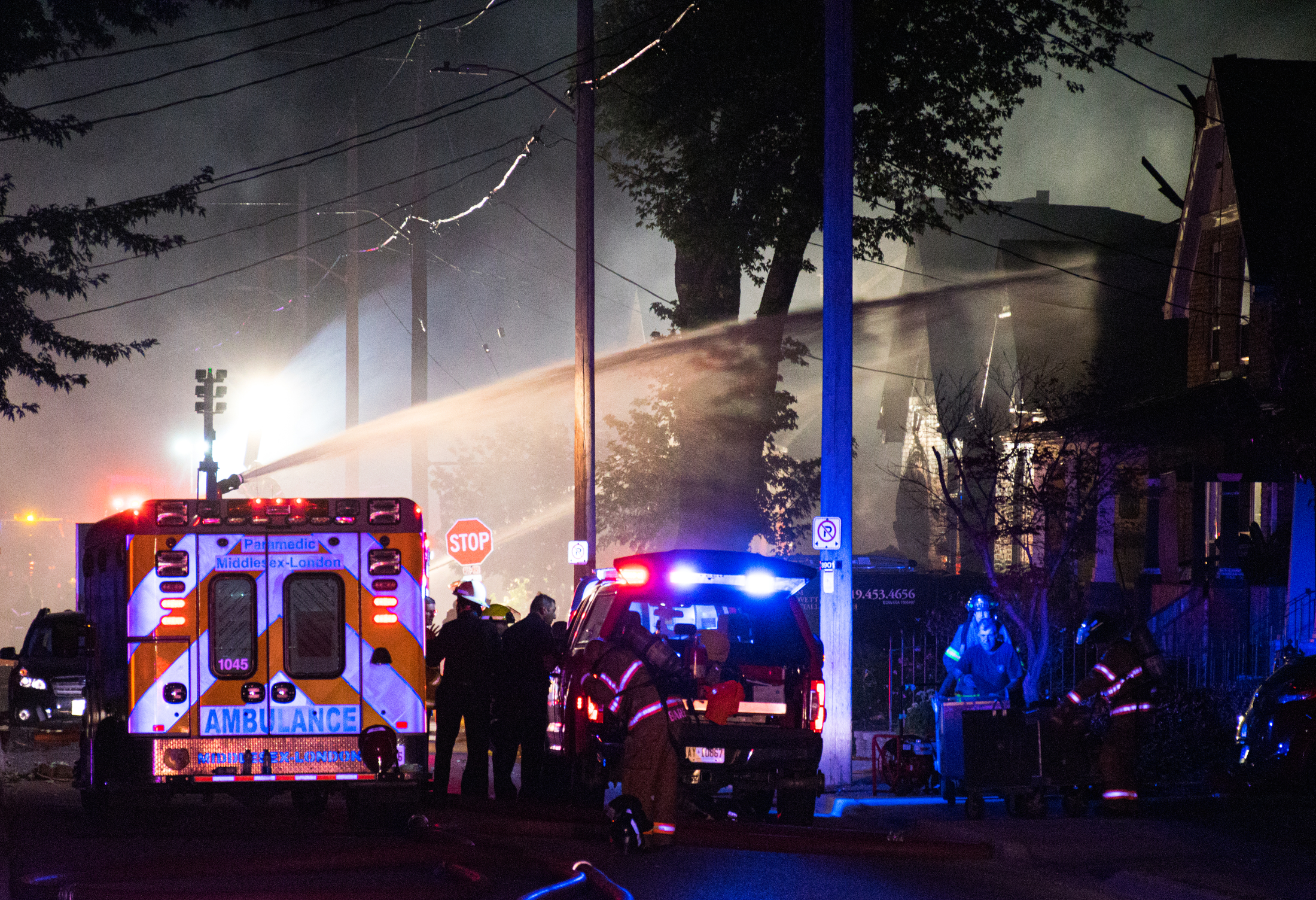 Fire crews douse houses along Woodman Avenue.