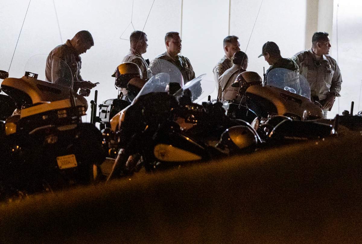 California Highway Patrol officers stage outside an emergency room entrance, late Monday, Aug. 12, 2019, in Moreno Valley, Calif., after a CHP officer was fatally shot during a traffic stop in Riverside. 