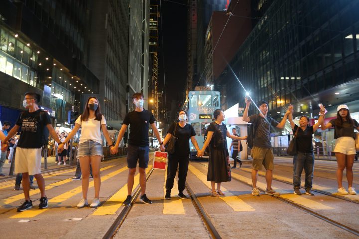 Protesters hold hands as they participate in the ‘Hong Kong Way’ in Hong Kong, Aug. 23, 2019.