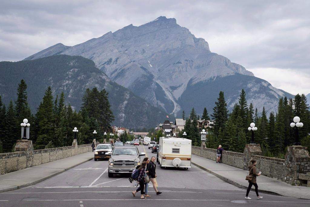 Pedestrians cross the street in Banff, Alta., in Banff National Park.