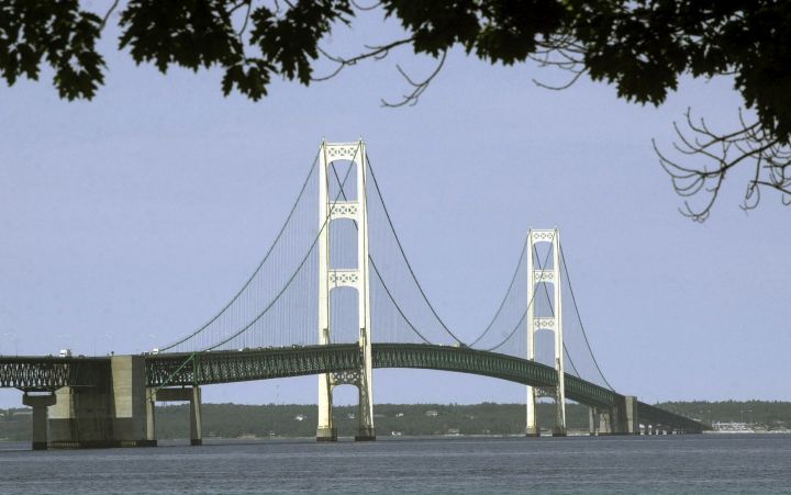 FILE - This July 19, 2002, file photo, shows the Mackinac Bridge that spans the Straits of Mackinac from Mackinaw City, Mich. Oil transport company Enbridge says Wednesday, a gap has opened between a section of its Line 5 pipeline and the lake bottom in Michigan's Straits of Mackinac. Erosion has washed away sediments beneath the pipeline, opening a gap that exceeds the 75-foot limit set under a state easement. The company says it's awaiting government permits to install screw anchors for additional support in that spot and others along the underwater line.