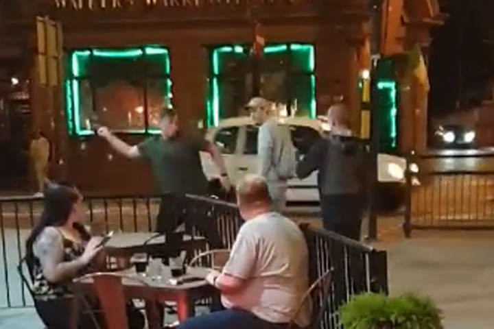 One man, left, throws a dead pigeon at his assailant, right, in this image from video recorded in Liverpool, U.K.