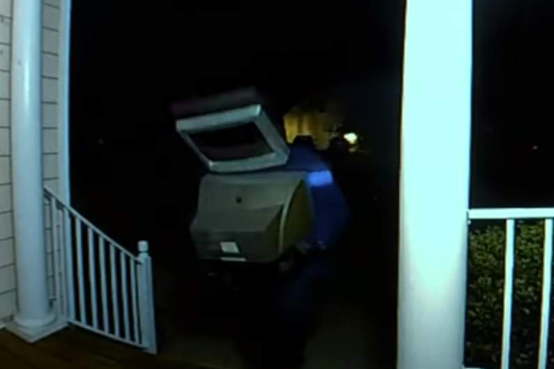 A man is shown with a TV on his head and another in his arms inis doorbell camera footage recorded on Aug. 11, 2019.