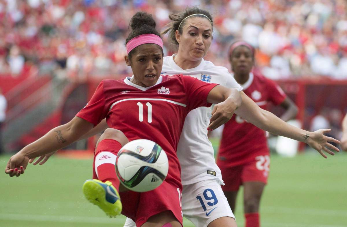 Canada's Desiree Scott, left, fights for the ball with England's Jodie Taylor during second half of FIFA World Cup quarter-final soccer action, in Vancouver on June 27, 2015.