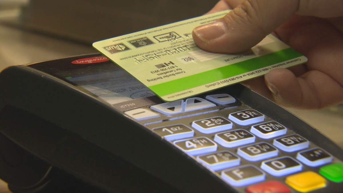 A debit card tapping on a payment machine.