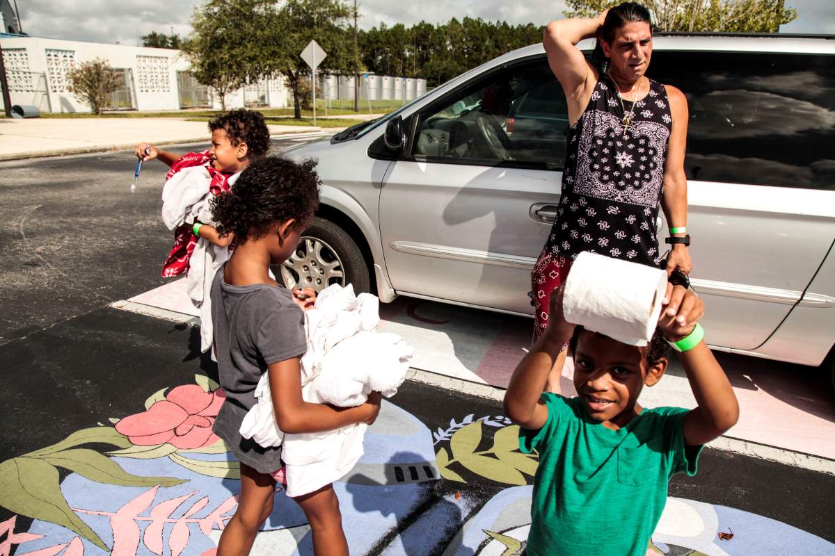 Matt Apuzzie, Javina Apuzzie, Steven Apuzzie, and Brian Apuzzie (L-R) get their last few supplies they gathered in their minivan at Pedro Menendez High School where they will be covering for shelter for hurricane Dorian in St. Augustine, Florida, U.S. September 2, 2019. REUTERS/Maria Alejandra Cardona