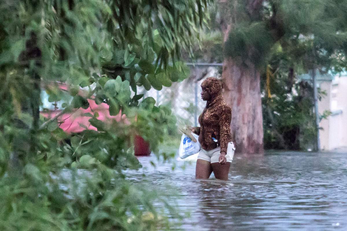 A woman walks in a flooded street after the effects of hurricane Dorian arrived in Nassau, Bahamas, September 2, 2019. (REUTERS/John Marc Nutt)