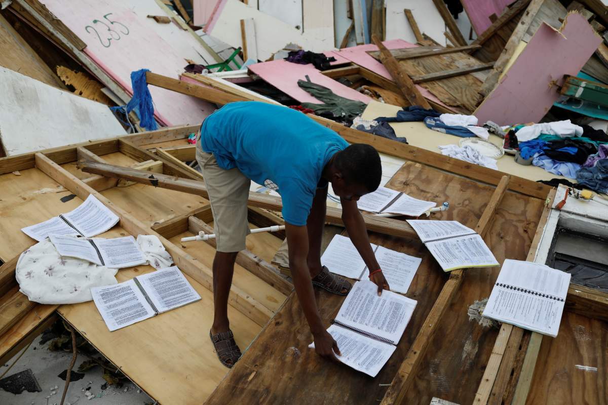 A man sundries wet books at the Mudd neighborhood, devastated after hurricane Dorian hit the Abaco Islands in Marsh Harbour, Bahamas. (Reuters)