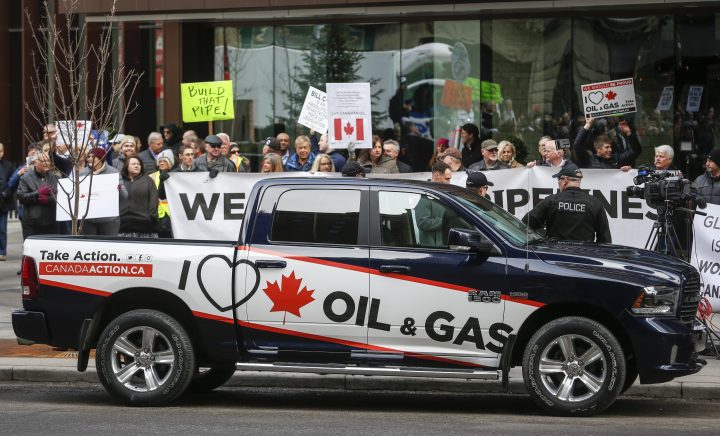 Pro-oil and gas supporters protest across the street as federal Finance Minister Bill Morneau speaks to the Economic Club of Canada about the 2019 federal budget in Calgary on March 25, 2019.