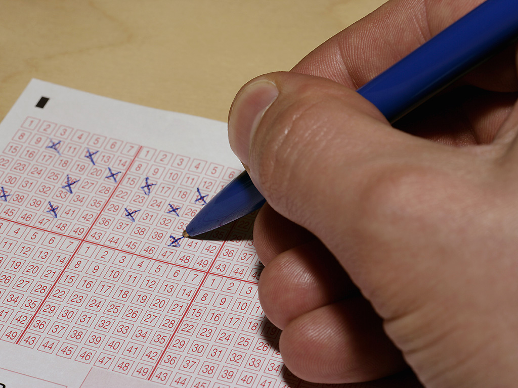 A man picks his numbers for a lotto ticket.