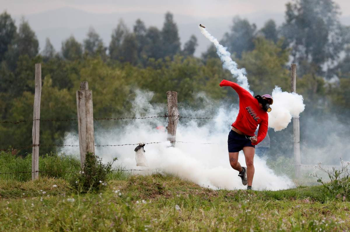 A demonstrator throws back a tear gas can as people blocking a road clash with soldiers during protests after Ecuador’s President Lenin Moreno’s government ended four-decade-old fuel subsidies, in Lasso, Ecuador, October 6, 2019.