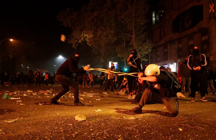 Catalan demonstrators use a slingshot to hurl stones during Catalonia’s general strike in Barcelona, Spain, Oct. 18, 2019.