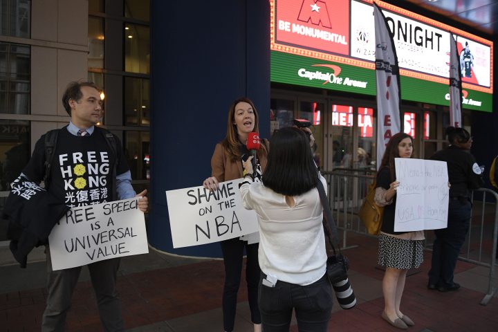 Activists hold signs outside Capital One Arena before an NBA preseason basketball game between the Washington Wizards and the Guangzhou Loong-Lions, Wednesday, Oct. 9, 2019, in Washington.