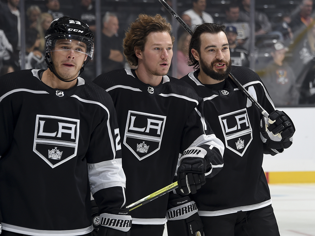 (L-R) Dustin Brown #23, Tyler Toffoli #73 and Drew Doughty #8 of the Los Angeles Kings talk during warm-up before the game against the Vegas Golden Knights at the Staples Center on Oct. 13, 2019 in Los Angeles, Calif.