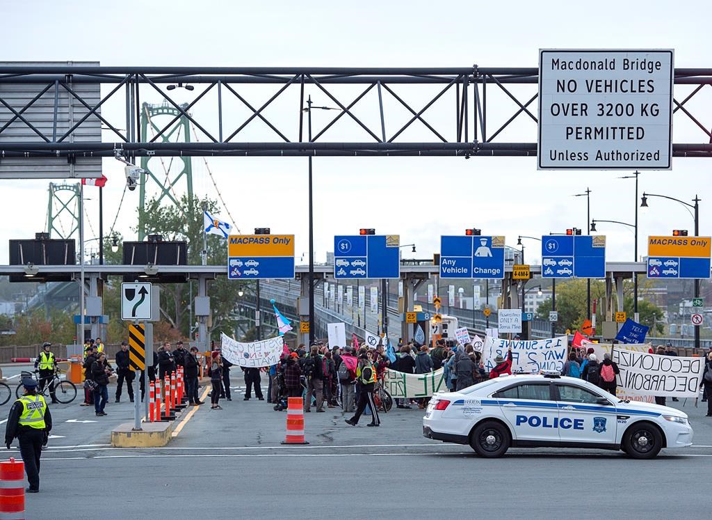 Members of Extinction Rebellion, protesting issues related to climate change, gather at the Angus L. Macdonald Bridge in Dartmouth, N.S. on Monday, Oct. 7, 2019.