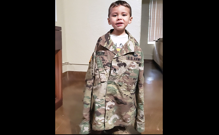 Omairis Taylor’s son Luke is pictured trying on her military uniform.