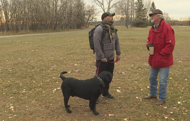 Veteran Damian Robertson (left) talks to Steve Critchley, founder of Can Praxis, at a walk for veterans in Calgary on Saturday, Oct. 19, 2019.
