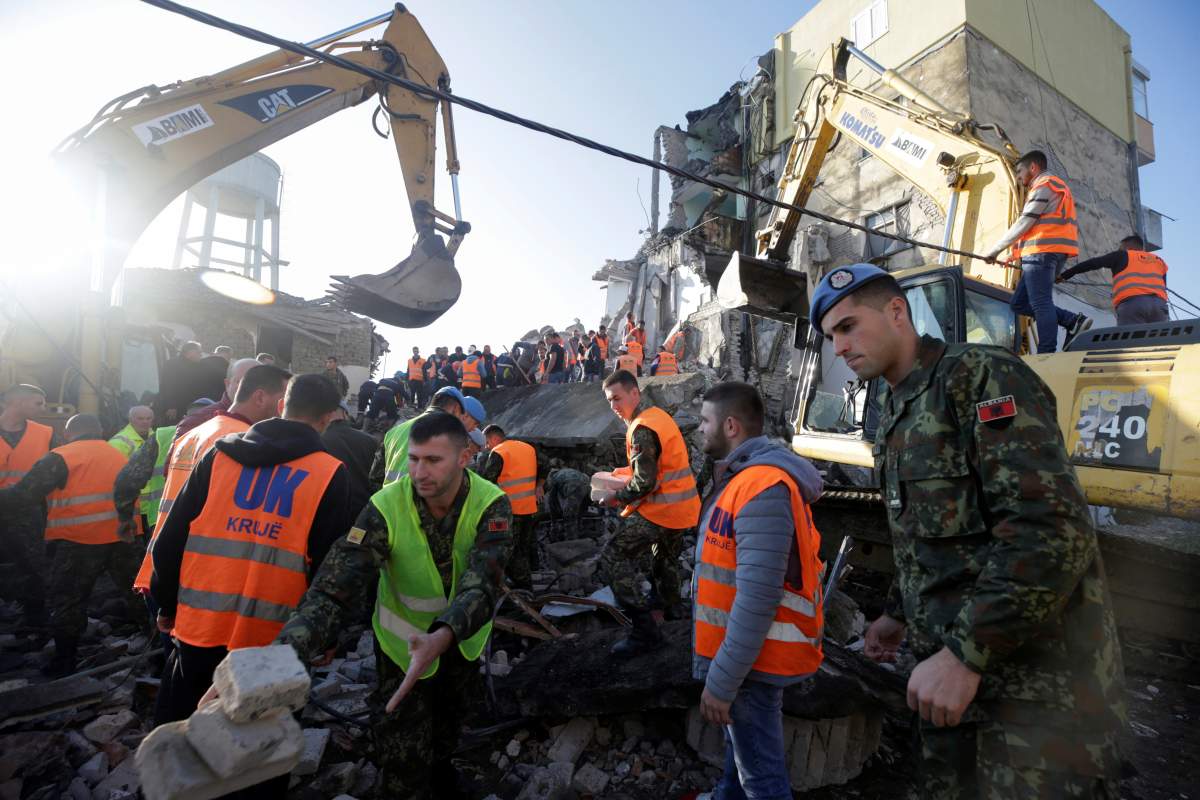 Emergency personnel work near a damaged building in Thumane, after an earthquake shook Albania, November 26, 2019. REUTERS/Florion Goga