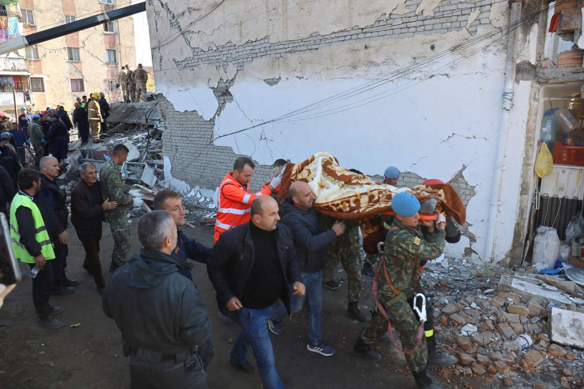 Military and emergency personnel carry an injured man on a stretcher near a damaged building in Thumane, after an earthquake shook Albania, November 26, 2019. REUTERS/Flatos Bytyci