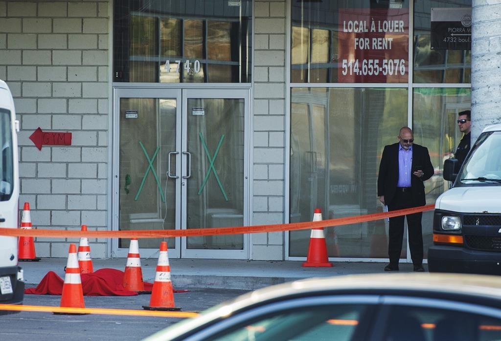 Investigators stand near the body of alleged mob boss Andrew Scoppa, who was shot to death, in Montreal, Monday, Oct. 21, 2019. After recording 17 organized crime-related killings in the greater Montreal area since Jan 1., Quebec and Montreal police announced Wednesday the creation of a permanent mixed squad dedicated to investigating groups such as the Mafia and the Hells Angels.