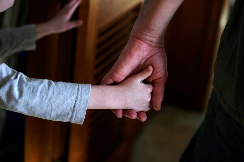 A child is shown holding an adult's hand.
