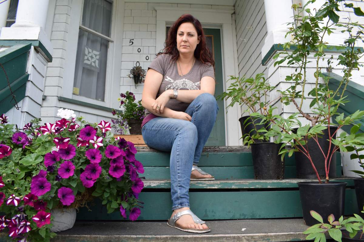 Florbela Cunha sits on the porch of her home, built in 1905, in Prince Rupert, British Columbia on July 21, 2019.