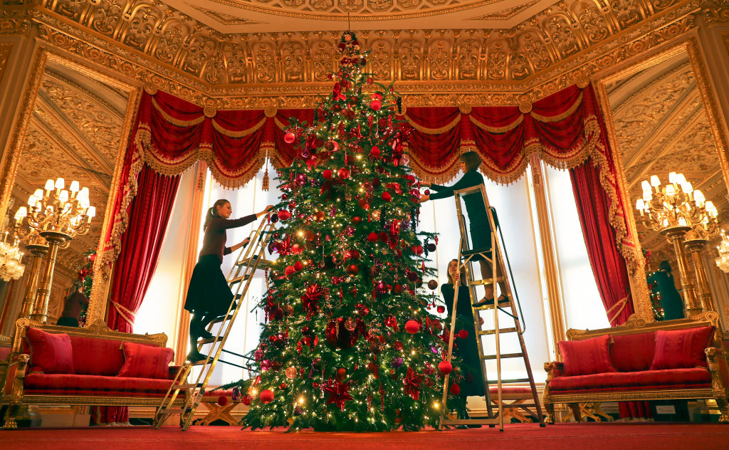 Royal Collection Trust members of staff put the finishing touches to a 15ft Christmas tree in the Crimson Drawing Room at Windsor Castle, Berkshire.